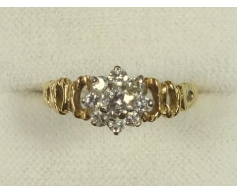 18 CT GOLD RING WITH SEVEN DIAMONDS IN A FLORAL SETTING FLANKED BY PIERCED SHOULDERS, GROSS, 2.7 GRAMS, EDWARDIAN 9 CT GOLD G