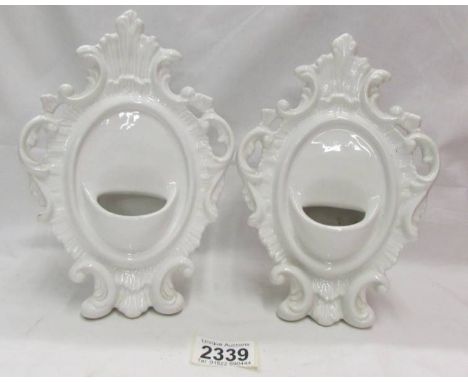 A pair of white ceramic pocket watch stands.