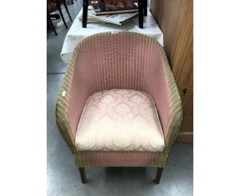 A pink Lloyd loom chair with upholstered seat with storage compartment