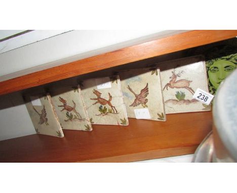 Five ceramic tiles depicting deer and one other.
