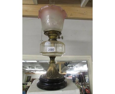 A Victorian oil lamp on pot base with glass font and complete with shade.