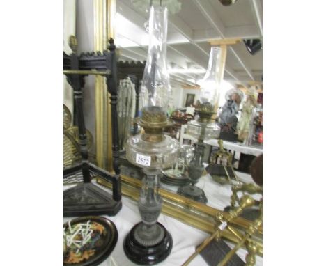A Victorian oil lamp with urn base, glass font and chimney.