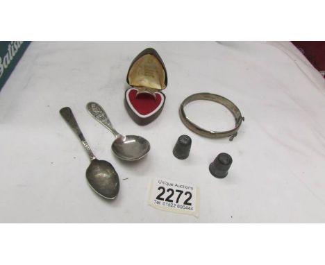 A silver ring, a silver bangle, a silver caddy spoon, a silver teaspoon and 2 thimbles.