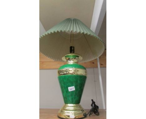 A green and gilded table lamp with shade.