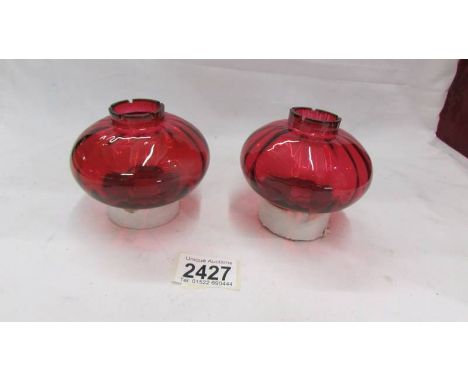 A pair of cranberry glass oil lamp peg fonts.