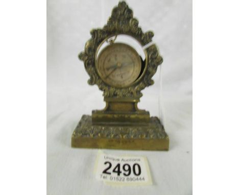 A brass pocket watch stand and a compass.