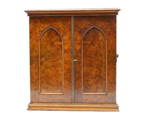 A Victorian burr walnut coin or collector's cabinet,with a moulded top and brass handles enclosing a pair of arched panel doo