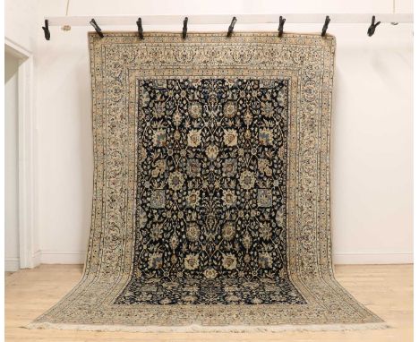 A Persian wool and silk Nain rug,20th century, the navy field woven with Shah Abbasi motifs, within pale stepped borders,330 