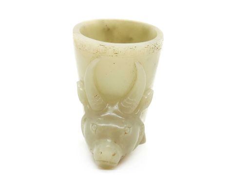 A Chinese jade buffalo cup,20th century, of oval form, the base rising from two hooved feet, carved with the head of a buffal