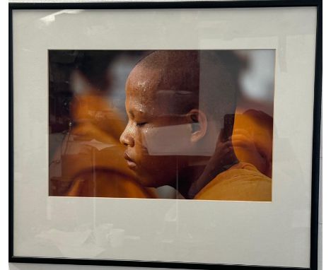 A framed photographic portrait of a young timed Buddhist Monk 61cm x 51cm 
