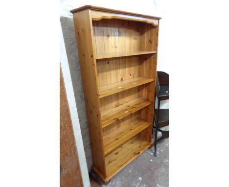 A 82cm modern polished pine five shelf open bookcase, set on bun feet