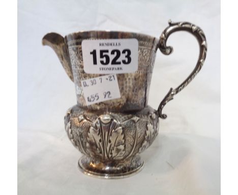 An early 20th Century silver ornate cream jug with cast scroll handle, hammered, incised and embossed acanthus decoration - L