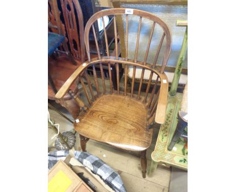 An antique elm hoop stick back elbow chair with solid moulded seat, set on turned supports