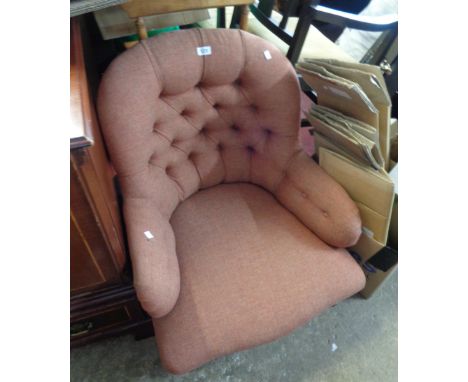 A late Victorian low armchair with button back upholstery, set on turned front legs and porcelain casters