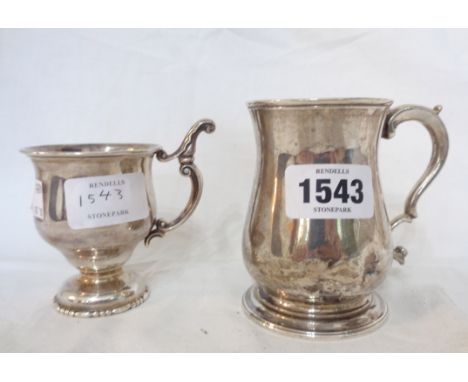 A silver footed cup with ornate cast scroll handle - sold with a small silver baluster tankard - dents