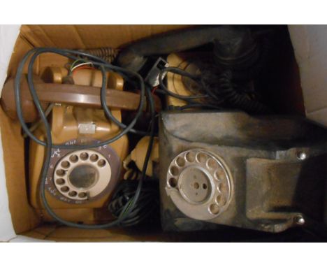 A box containing three vintage telephones