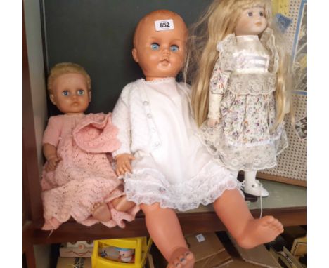 Two vintage dolls with associated clothes and one modern doll on stand