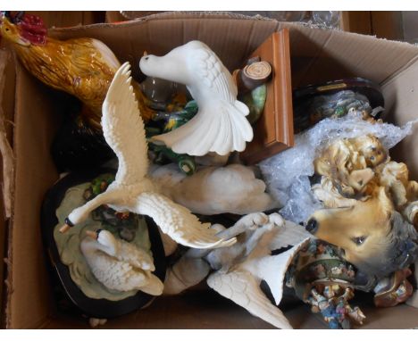A box containing a large quantity of resin and ceramic figurines