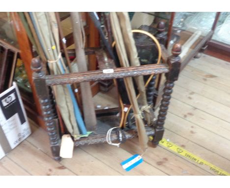 A late Victorian carved oak stick stand with bobbin turned supports and repaired metal drip tray