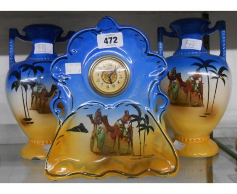 A 1920's china clock garniture with printed Arab figure decoration on blue and sand coloured ground, with simple thirty hour 