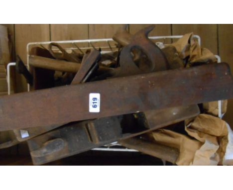 A basket containing assorted woodworking and other tools including planes, chisels, etc.