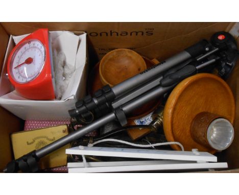 A box containing assorted collectable items including table lamp, camera tripod, wooden bowls, etc.