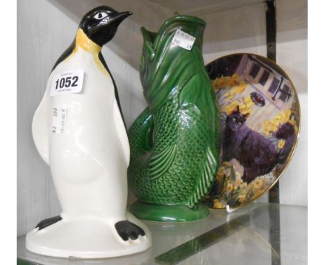A Poole Pottery penguin figurine, a Dartmouth pottery gurgle jug and a Spring is in the Air collector's plate