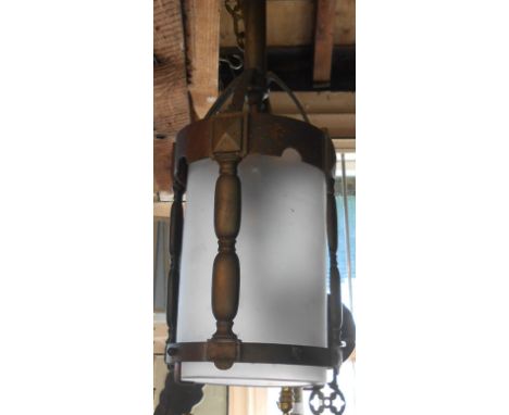 An early 20th Century hanging brass hall lamp in the Gothic style with pillared gallery, frosted shade and pierced decorative