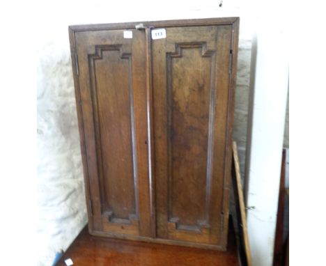 A 48cm early 20th Century oak two door cabinet with panelled decoration