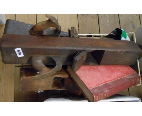 A crate containing an assortment of old woodworking tools including planes, chisels, scribes, etc.