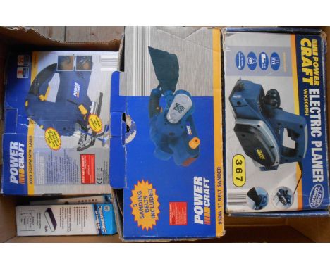 A box containing three Power Craft electric tools comprising belt sander, planer and jigsaw with two replacement sanding belt