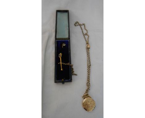 A 9ct. gold front and back circular locket, on yellow metal chain - sold with a stick pin case containing pin, brooch and par