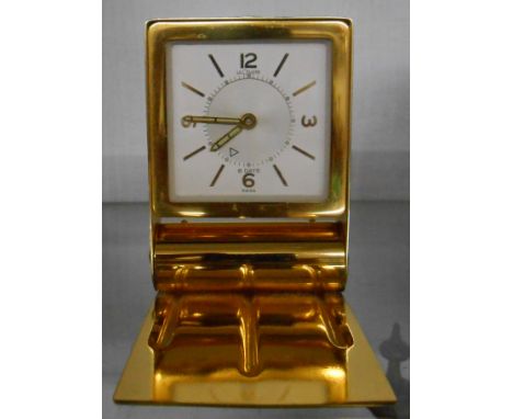 A polished brass folding cased Le Coultre travelling alarm clock with time set pointer to centre of dial