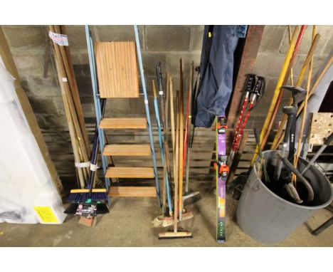 A quantity of various long handled tools to include brooms, rakes, etc