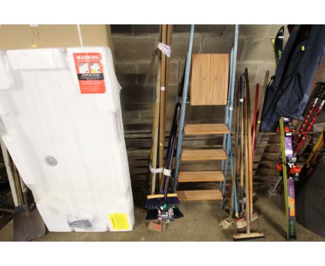 A quantity of various long handled tools to include brooms, rakes, garden hoe etc