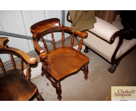 A Victorian elm seated smokers bow elbow chair 