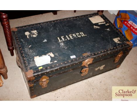 A large metal bound travelling trunk and contents to include bedspreads and cushions