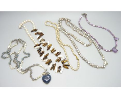 A collection of pearl necklaces, one set with amethyst, and one with Tiger's Eye