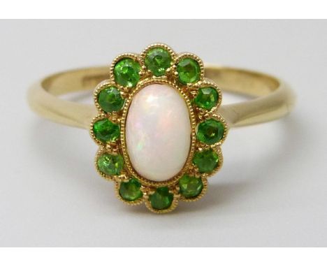 An early 20th Century 18ct yellow gold halo ring set with Demantoid garnets and an opal, 2.3g, M