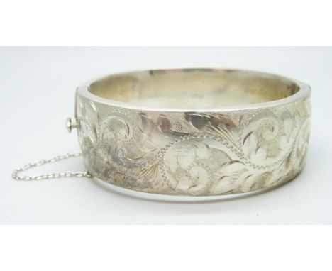 An engraved silver bangle, 37g, 2.2cm wide, 6 x 5.5cm