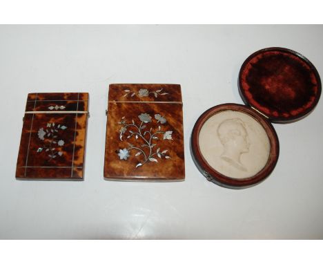 Two tortoiseshell and mother of pearl inlaid card cases, 7cm wide and smaller (af) and a wax relief, 7cm wide in original cas