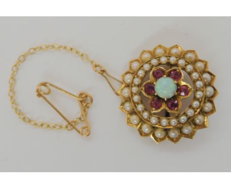 A 15ct gold Edwardian flower brooch set with pearls, rubies and an opal, diameter 2.2cm, weight 4.8gms Condition Report: Avai