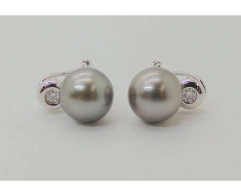 A pair of 18ct white gold pearl and diamond earrings, the large grey pearls are approximately 10.5mm in diameter, and set wit