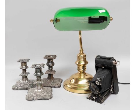 A Brass and Green Glass Desk Lamp, kodak camera, and three plated candlesticks