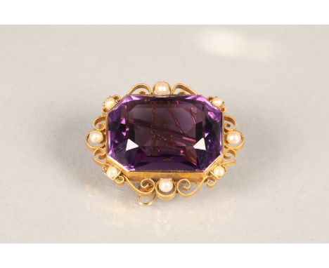 Large 15 carat gold amethyst brooch, emerald cut amethyst set with pearl seeds in a gold mount with scroll work edges The bro