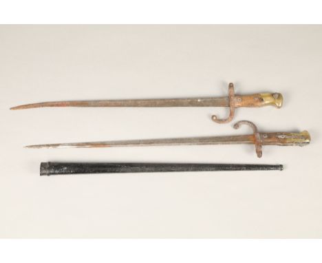 Two French bayonets, one with scabbard and one without, with wooden and brass grips.&nbsp;