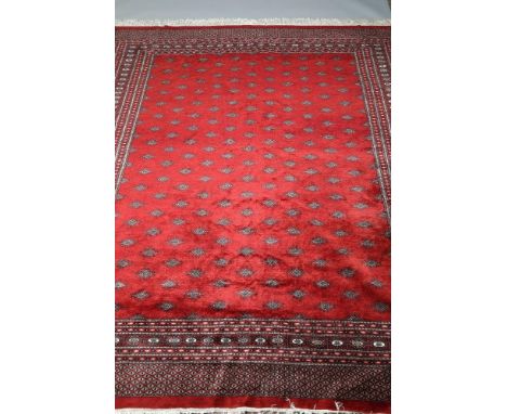 Large very fine Bokhara red ground carpet, geometric medallions with a stylised starburst border. 305cm x 250cm