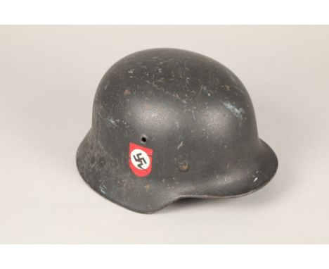 World War II German double decal steel combat helmet, with leather liner with later SS insignia to one side and swastika to t