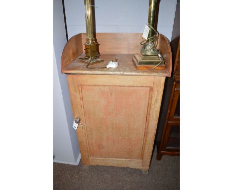 A 19th Century stripped pine cupboard with shaped gallery and a single panelled door enclosing shelves and raised on bracket 