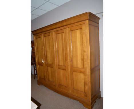 A modern French style oak double wardrobe with flared cornice with four panelled doors opening to reveal hanging spaces and s